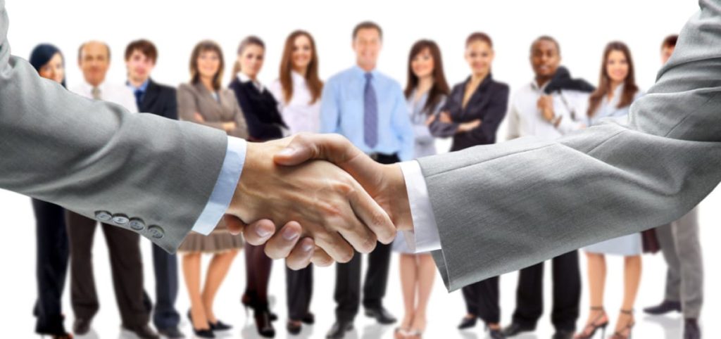 una imagen de 2 personas dandose la mano en un negocio y un grupo de personas observandolos Edycon Cubiertas, SAS